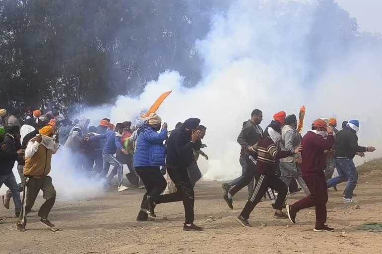 Indian farmers took cover as police fired tear gas to disperse protestors near the Punjab-Haryana border, en route to New Delhi 