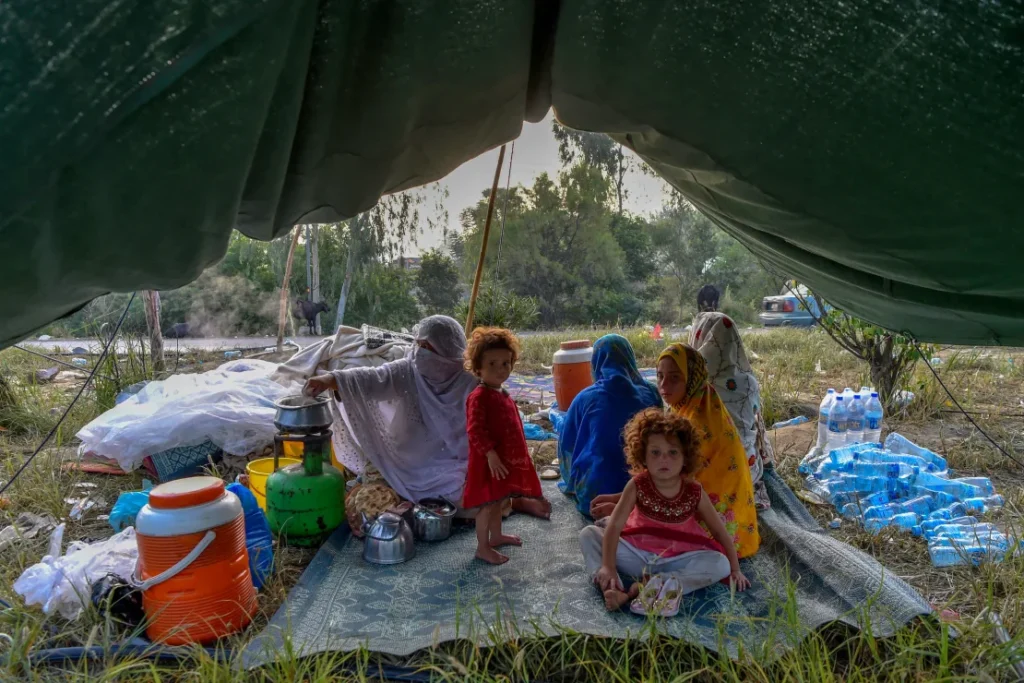 Impact of floods and climate change: Displaced people prepare for breakfast in their tents at a makeshift camp after fleeing from their flood-hit homes following heavy monsoon rains in Charsadda district of Khyber Pakhtunkhwa on August 29, 2022.