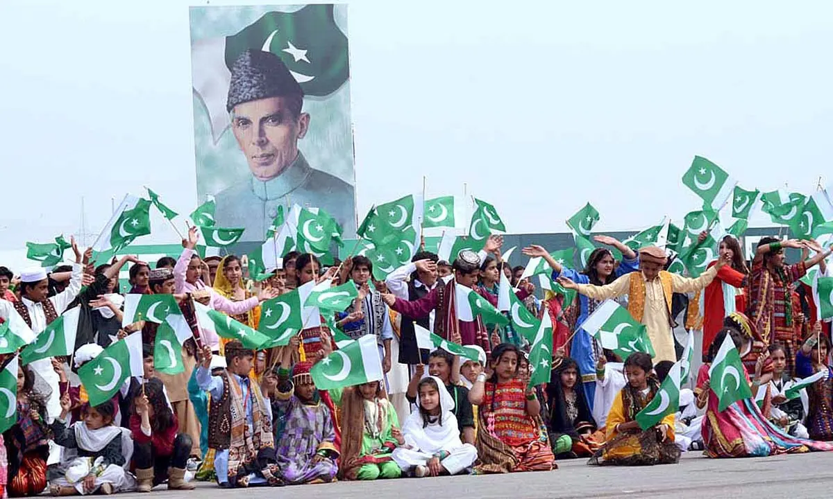 Children are carrying National Flag to celebrate Pakistan Day.